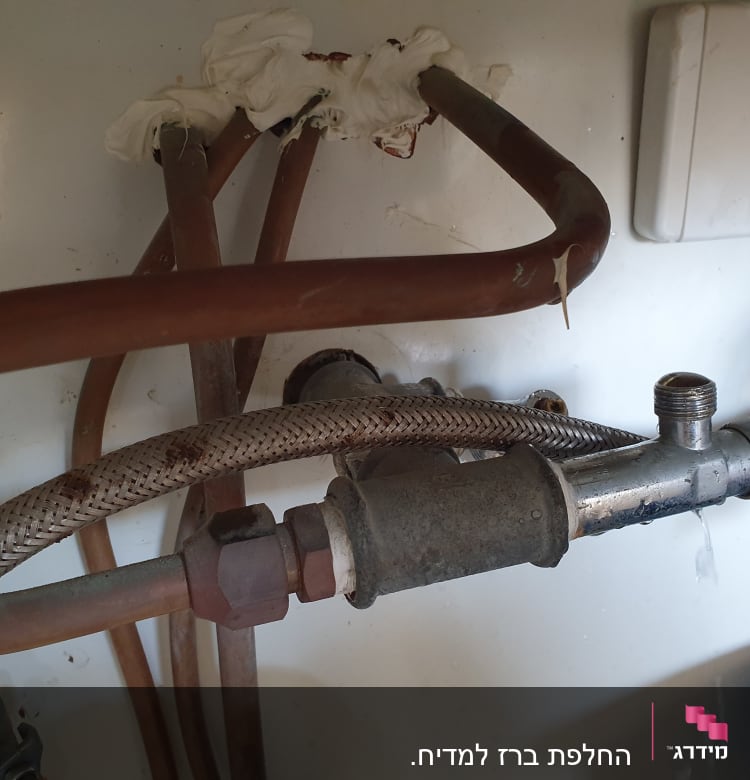 צינורות מתכת וברז דולף מתחת לכיור